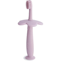 Soft lilac silicone training toothbrush with a flower-shaped handle and textured bristles for toddlers.