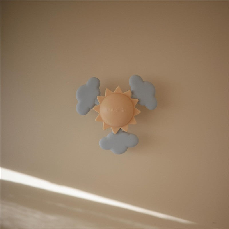 Suction spinner toy featuring a central sun surrounded by soft, gray clouds, ideal for sensory play.