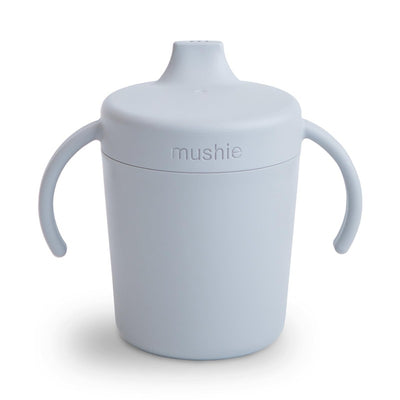 Trainer sippy cup by Mushie in a soft cloud color, featuring two handles and a spill-proof lid.