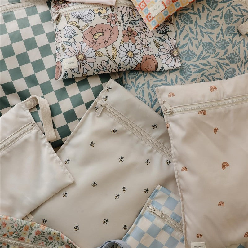 Mushie Water Resistant Wet Bags in a 2 pack featuring floral and bee patterns, displayed on a light background.