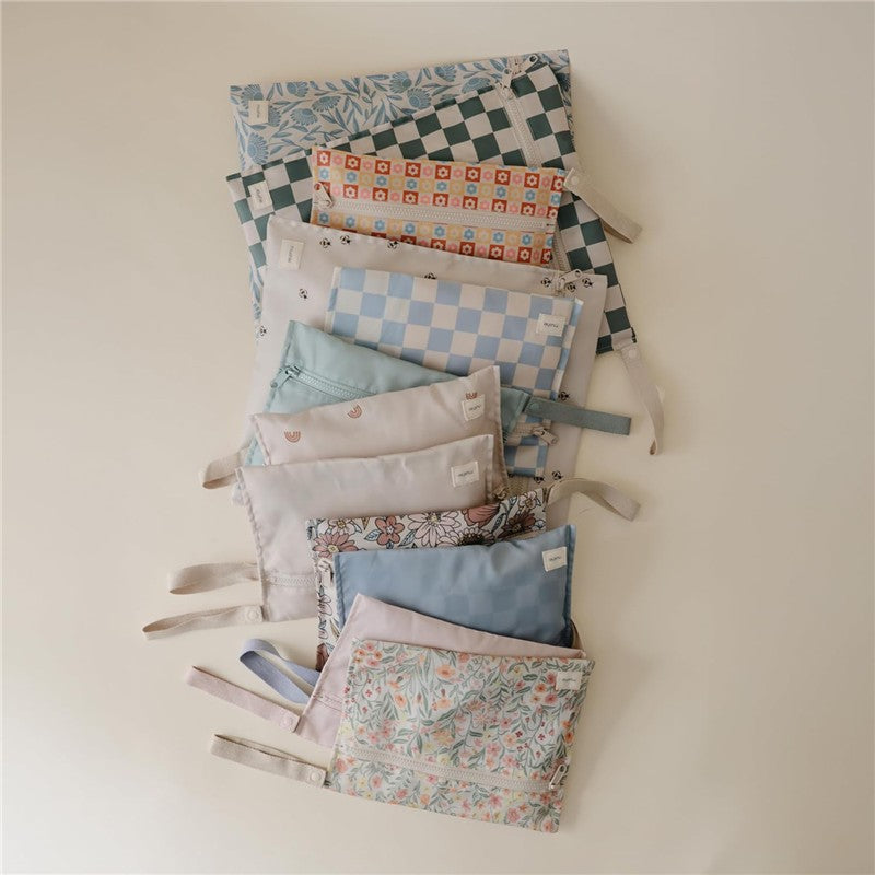 Mushie Water Resistant Wet Bag two-pack featuring blue floral designs and various patterns, ideal for keeping items dry.