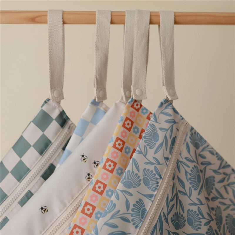 Water-resistant wet bags in blue floral patterns, featuring zip closures and fabric loops for easy hanging.