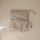 Mushie water-resistant wet bag two-pack in a soft pink color with gold star patterns, featuring a large and a small bag with zippers.