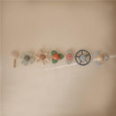 Colorful Mushie Water Wheel Bath Toy set featuring various playful designs including flowers and a steering wheel.
