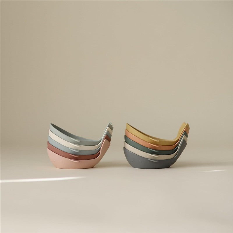 Mushie Whale Bath Stackers in pastel colors, designed for stacking and bath play, displayed against a neutral background.