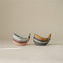 Mushie Whale Bath Stackers in pastel colors, designed for stacking and bath play, displayed against a neutral background.