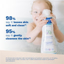 Mustela Multi-Sensory Bubble Bath bottle held by a child in a bath, with claims about skin softness and cleansing.