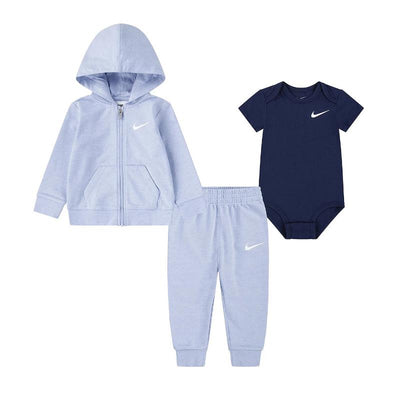 Nike Baby 3Pk Bodysuit Pant Set featuring a light blue zip-up hoodie, matching pants, and a dark blue bodysuit, all with logo details.