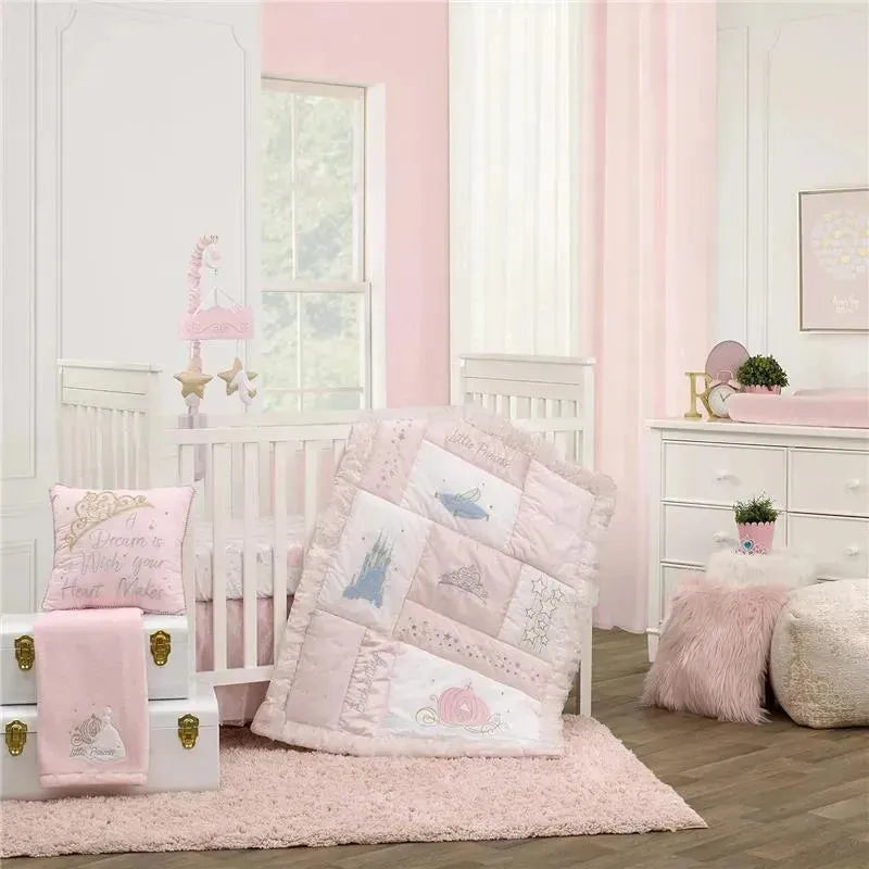 Nojo - Disney Princess Enchanting Dreams baby blanket in pastel pink, featuring princess motifs and a soft texture, draped over a crib.