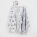 Dumbo-themed muslin swaddles in gray and white, featuring elephant prints and cloud patterns, hanging on a wall hook.