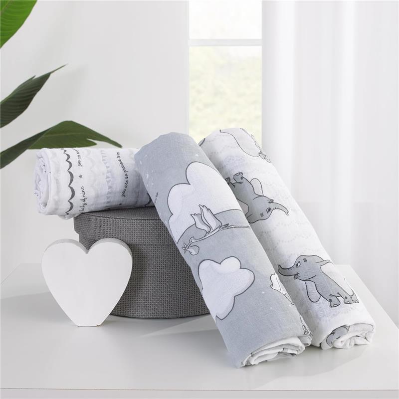 Three Nojo Dumbo printed muslin swaddles displayed on a gray fabric basket, featuring cartoon elephants and clouds.