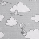 Muslin swaddle featuring grey clouds, flying storks carrying bundles, and a Dumbo character in a parachute.