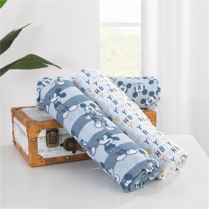 Three printed muslin swaddles featuring Mickey Mouse designs, displayed on a vintage box.