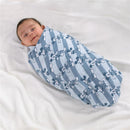 Smiling baby wrapped in a blue and white striped muslin swaddle featuring Mickey Mouse prints.