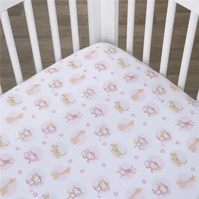 Fitted crib sheet featuring playful animal designs, including monkeys and giraffes, on a soft pink background.