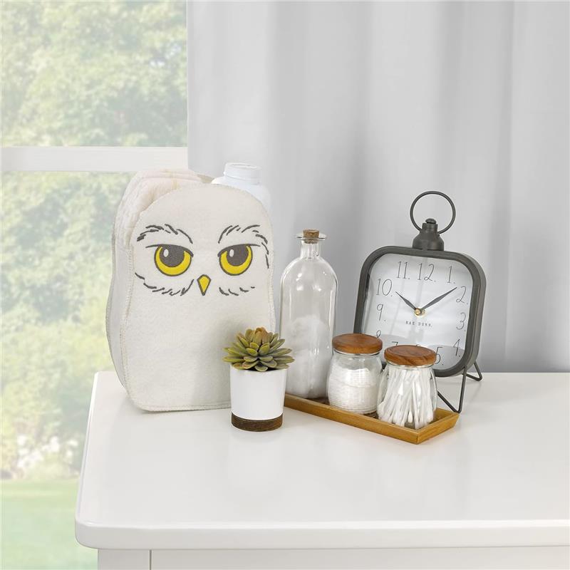 Felt storage bag designed as Hedwig from Harry Potter, alongside decorative items and a clock on a white surface.
