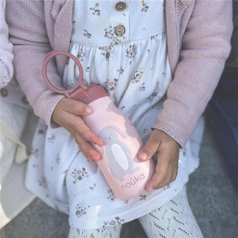 Insulated stainless steel kids water bottle by nouka, featuring a cute bunny design, held by a child in a floral dress.