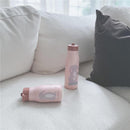 Nouka 10 oz insulated stainless steel kids water bottles in pink, featuring a cartoon rabbit design, placed on a couch.