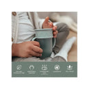 Moss-colored Nouka all-around cup with removable handles, held by a child, featuring labels for safety and use.