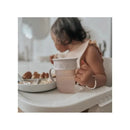 Nouka - All Around Cup, Wave held by a toddler at a high chair, featuring a frosted design and a decorative outer layer.