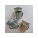 Set of three Nouka All Around Cups in muted colors: light green, dark green, and beige, featuring two handles and a decorative rim.