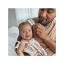 Father gently combs the hair of a smiling baby girl sitting on his lap, showcasing a baby grooming kit.