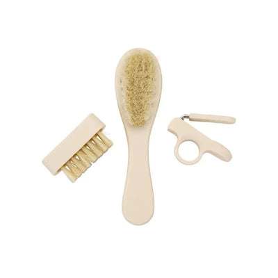Baby grooming kit featuring a soft-bristled brush, a fine-toothed comb, and a nail clipper, all in muted beige colors.