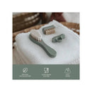 Baby grooming kit featuring a soft brush and silicone accessories on a textured white cloth, highlighting safety and ease of cleaning.