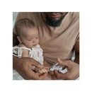 A parent gently clips the nails of a baby using the Nouka Baby Nail Clipper in Lily Blue.