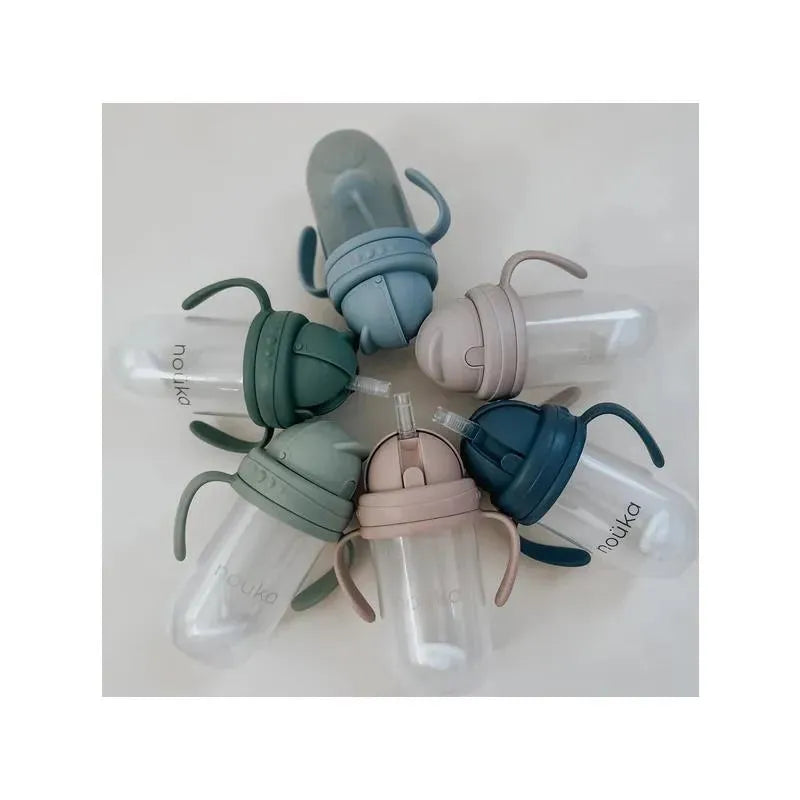 Non-spill weighted straw cups by Nouka in soft sand and various colors, featuring handles and clear lids.