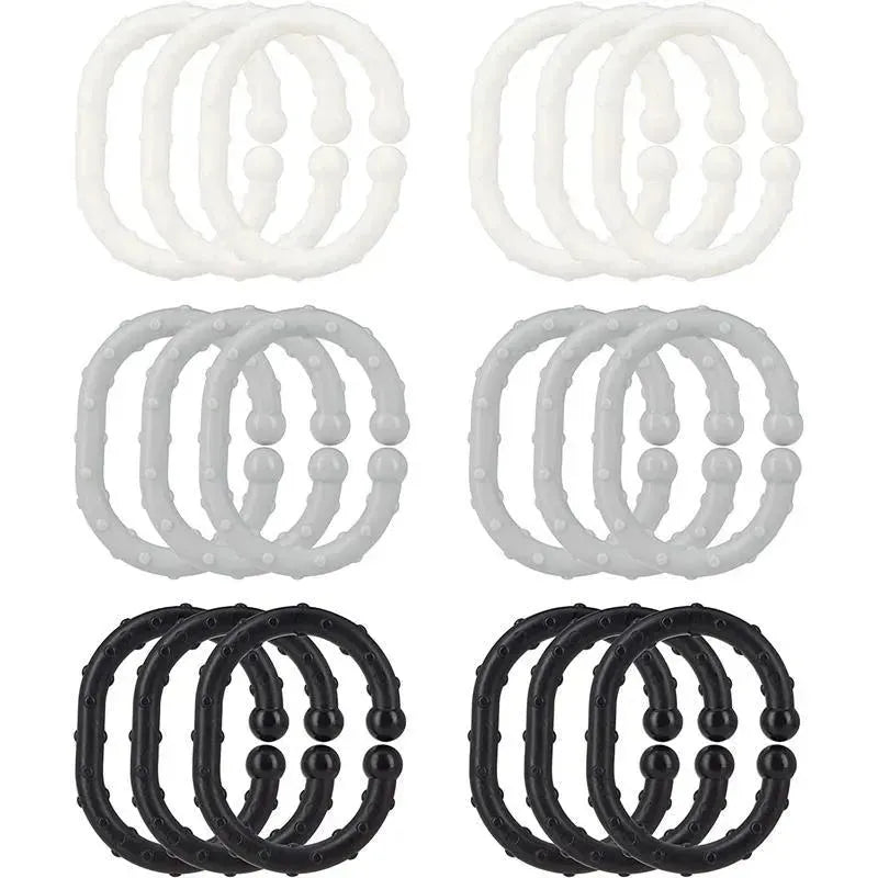 Eighteen Nuby Linkables teething toys in black, gray, and white, featuring textured rings for infants to chew on.