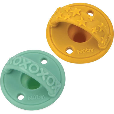 Two Nuby 3D silicone pacifiers in yellow and green, with textured handles and hole details, designed for infants 0M+.
