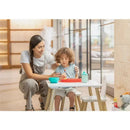 A mother assists a child at a table with a Nuby sectioned silicone feeding mat, featuring vibrant food in bowls.