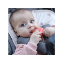 Baby holding a Nuby silicone feeder and post teether, nibbling on food while sitting in a stroller.