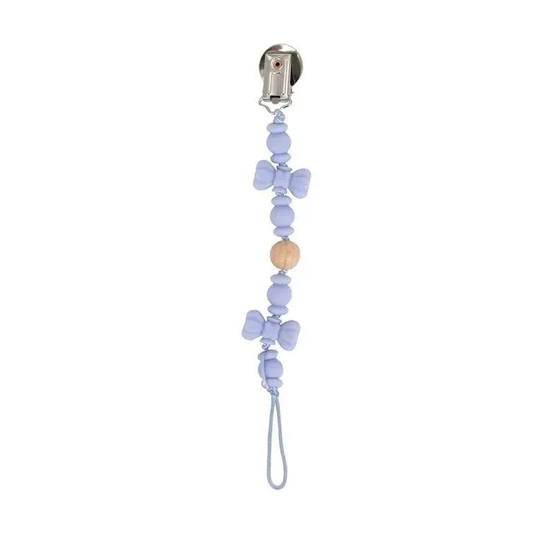 Silicone and wood beaded pacifier clip holder in lavender with stainless steel clip and bowtie accents.