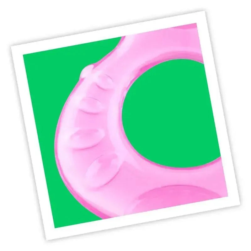 Soft pink silicone teether with textured surfaces, designed for infants to soothe gums, set against a green background.