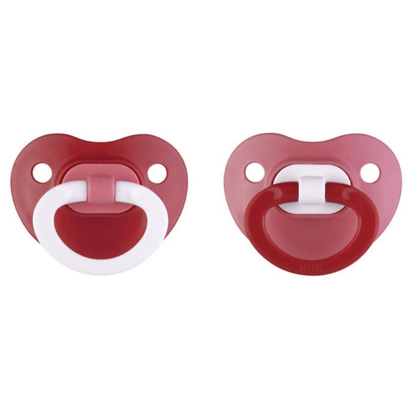 Two assorted red Nuk pacifiers, featuring round shapes and white handles, designed for infants.