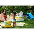 Child drinking from a Nuk Active Hard Spout Sippy Cup while playing outdoors near a yellow cooler and a small inflatable pool.