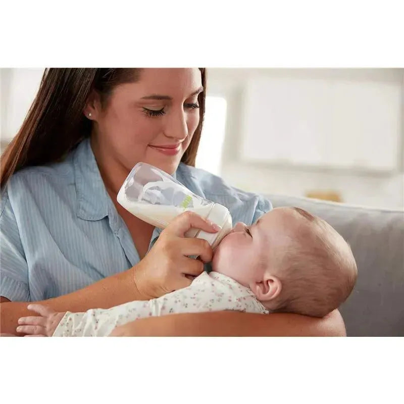 Mother feeds a baby with a Nuk Simply Natural baby bottle, showcasing the gentle bond between them.