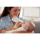 Mother feeds a baby with a Nuk Simply Natural baby bottle, showcasing the gentle bond between them.