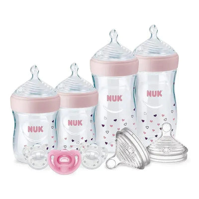 Nuk Simply Natural Baby Bottles gift set in pink featuring 4 bottles, 3 pacifiers, and 2 replacement nipples.
