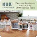 Weighted straw cups and other NUK products displayed on a wooden kitchen counter, with eco-friendly packaging information visible.
