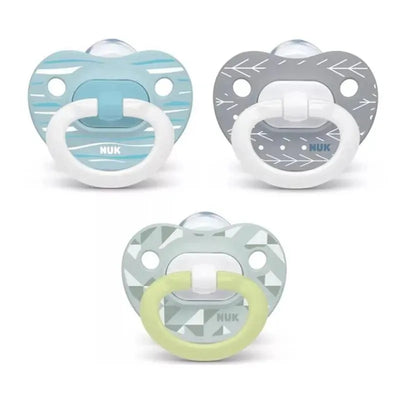 Set of three Nuk pacifiers in blue, gray, and mint green, featuring various patterns and white handles.