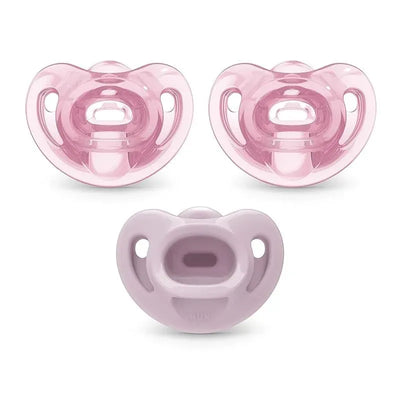 Three pink Nuk pacifiers sized for girls, featuring a rounded shape and a comfortable design for infants.