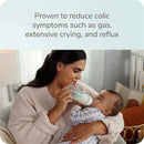 Nuk Smooth Flow Pro Anti-Colic Baby Bottle held by a woman feeding a baby, with text about reducing colic symptoms.