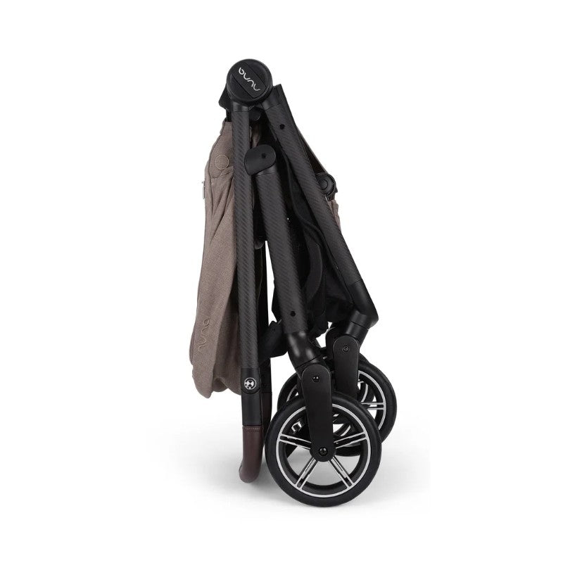 Nuna BMW Swiv stroller folded for storage, featuring a carbon fiber frame and sleek black wheels.