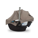 Nuna Pipa Rx infant car seat in cedar color with adjustable canopy and safety features visible on the side.