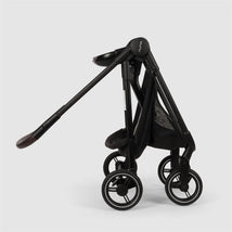 Nuna Flex System Frame in Caviar color, featuring a sleek design, extendable handle, and four wheels for mobility.