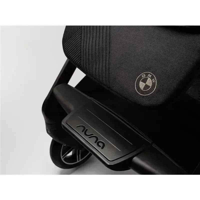 Nuna MIXX™ next Stroller featuring a magnetic buckle, with a logo and a BMW emblem on the seat.