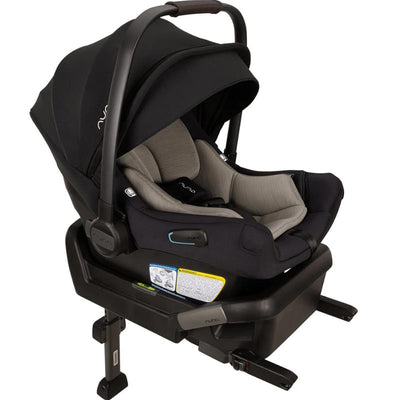 Nuna PIPA™ aire Infant Car Seat in Caviar color with a gray seat insert, attached to PIPA™ Series Base, safety labels visible.